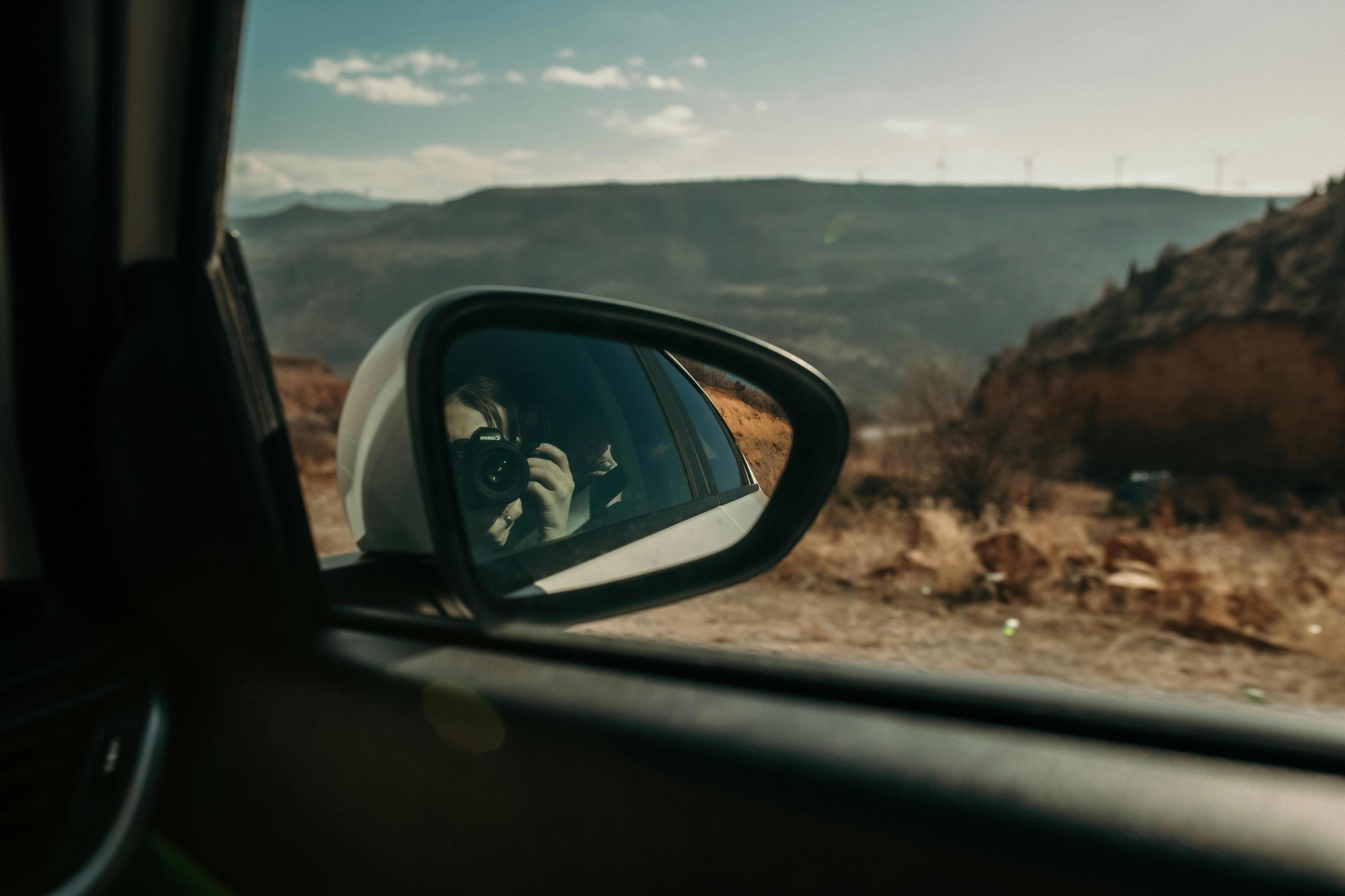 car side mirror showing mountain range